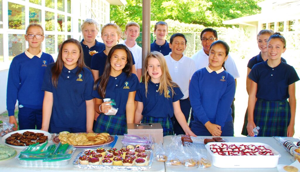 children standing by the bake sale table