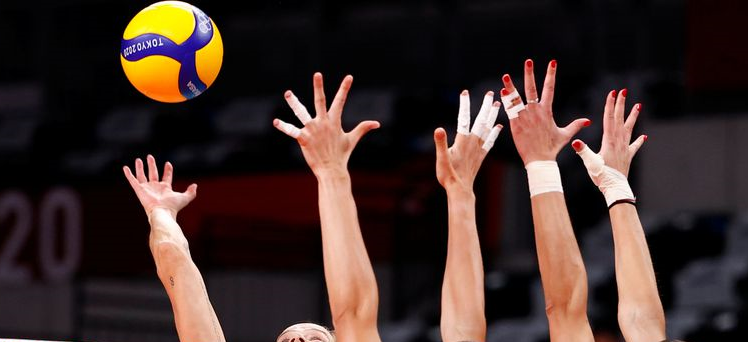 photo of hands reaching for the volleyball